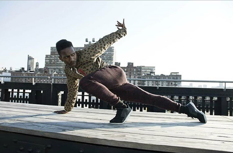 A man does a cat lunge to the side on a wooden platform