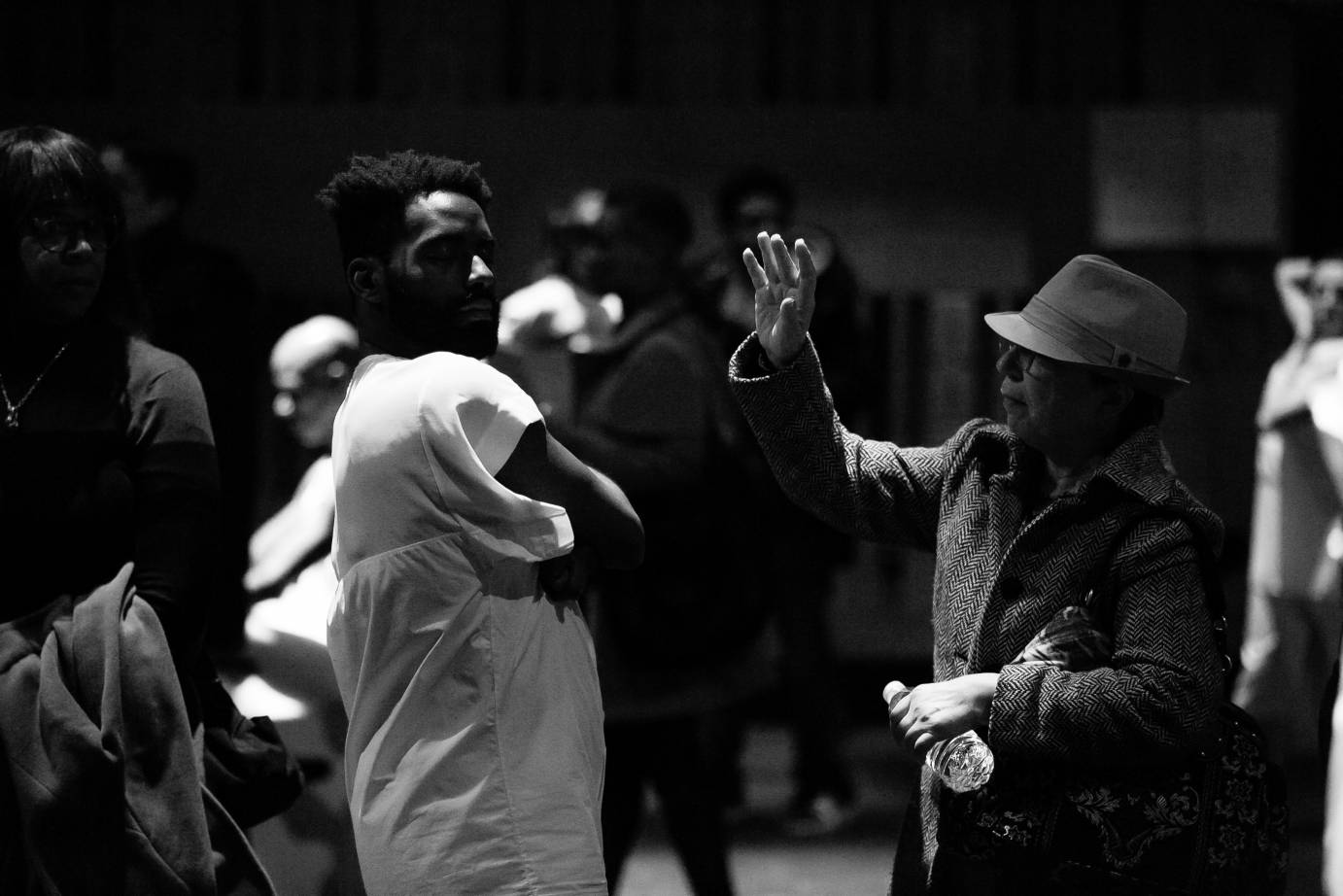 Jerron Herman stands with his arms crossed as a pedestrian reaches an arm to him