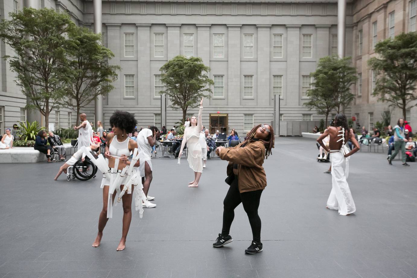 ON DISPLAY features a cast in white on the street as a pedestrian interacts