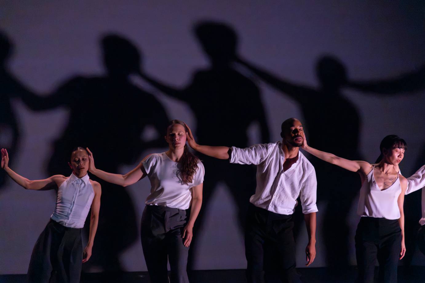 Dancers facing forward eyes closed place on palm on the cheek of the dancer to their left.