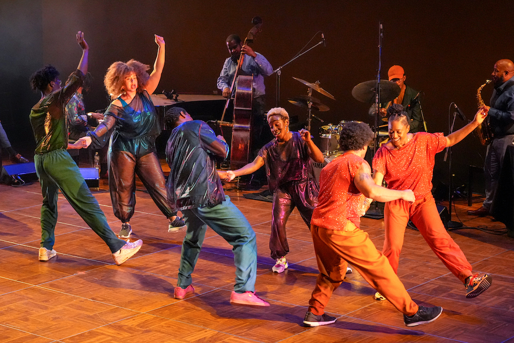 a group of Black dancers, paired off with dancing jubilantly...