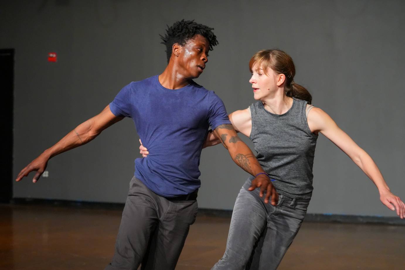 Jamie Scott hugs Mufutau Yusuf's waist as the two artists appear to be running together.