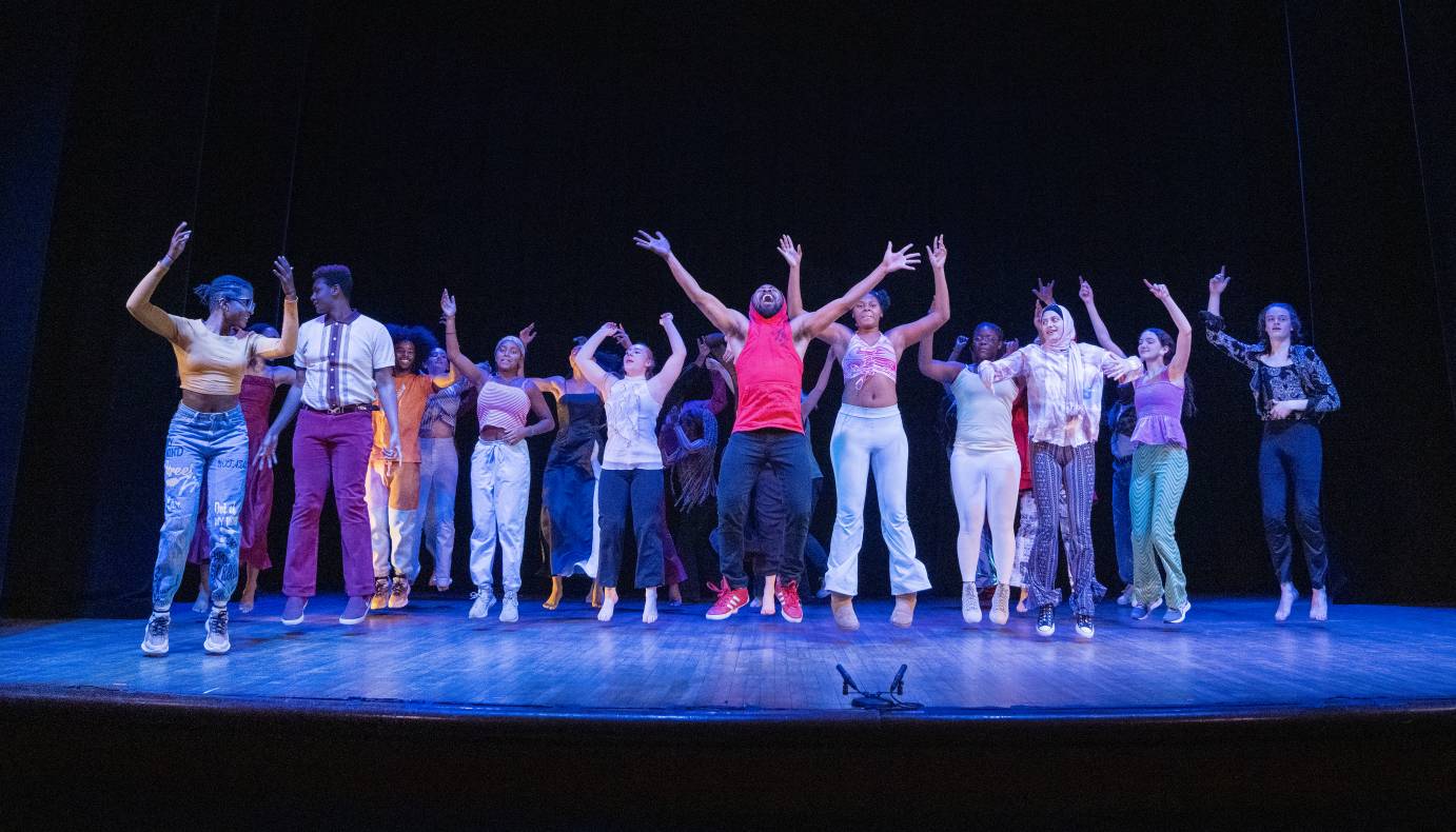 Johnnie Mercer jumps up in ecstacy, mouth wide open arms high in the air. He is surrounded by highschool students who imitate his gesture and jump. What great fun.