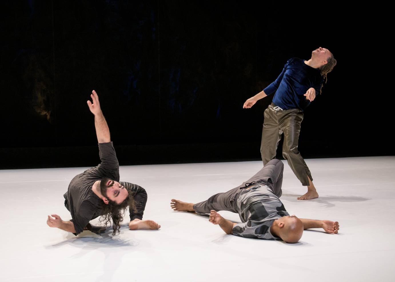 Three dancers contort their bodies