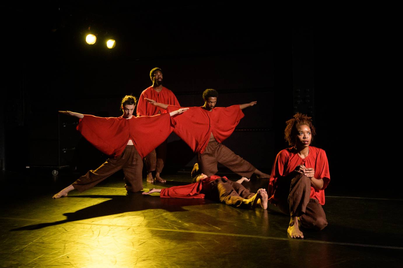 Five dancers form a multi-height cross