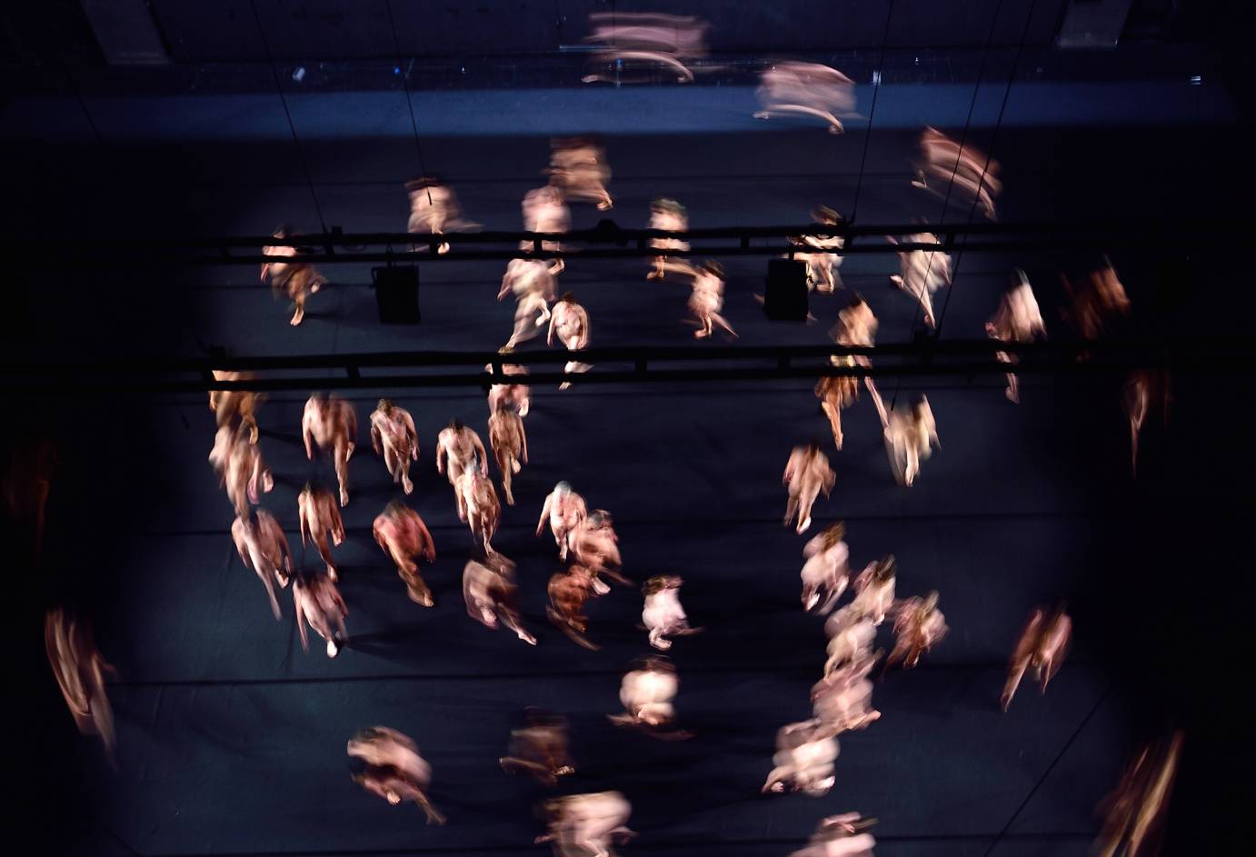 A god's eye view of naked people walking in a circle