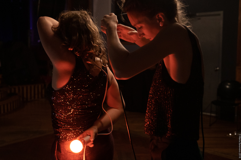 Two women playing with a light