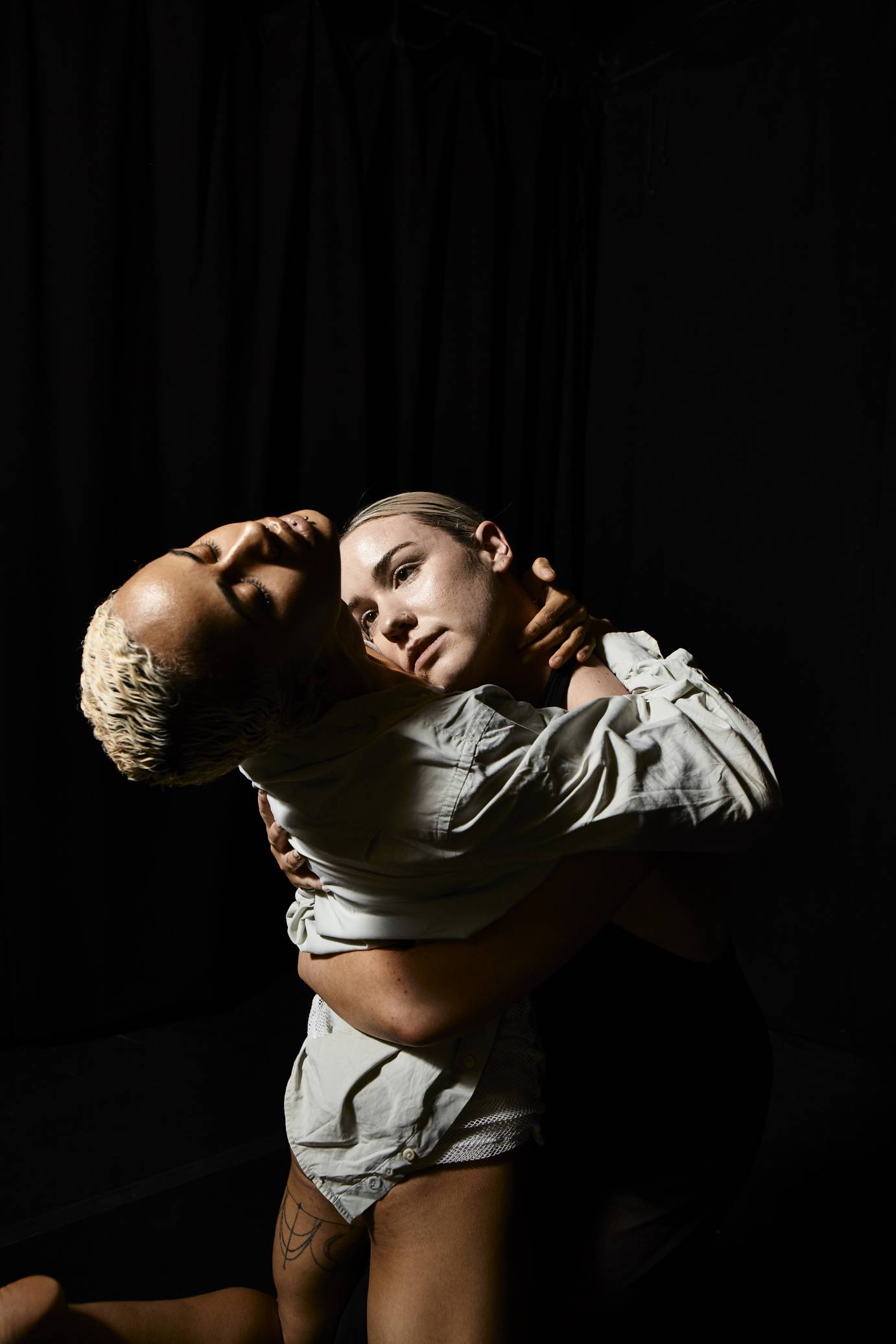Two dancers grapple in a sensuous hug