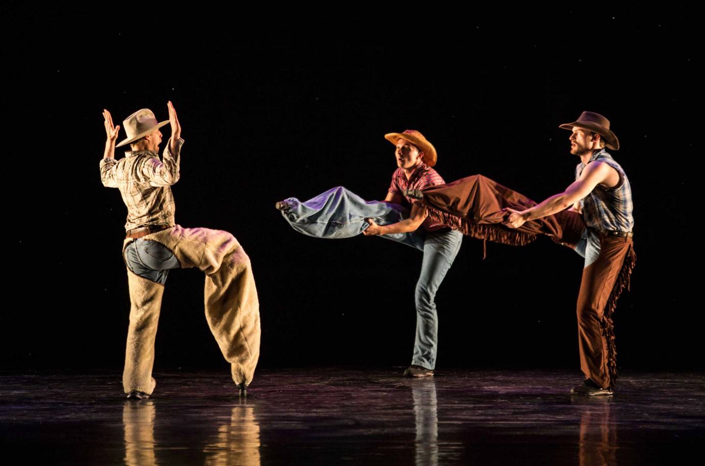 Three men dressed as cowboys.