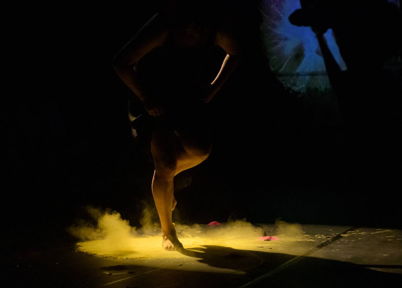 Woman's feet kick up yellow powder