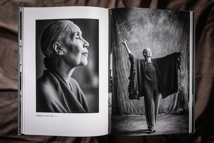 a book opened to the page showing an elegant profile of elder  stateswoman of dance Carmen de Lavallade, the second page shows Ms de Lavallade striking a simple pose with her arms raised and head lifted showing off the drapery of a scarf