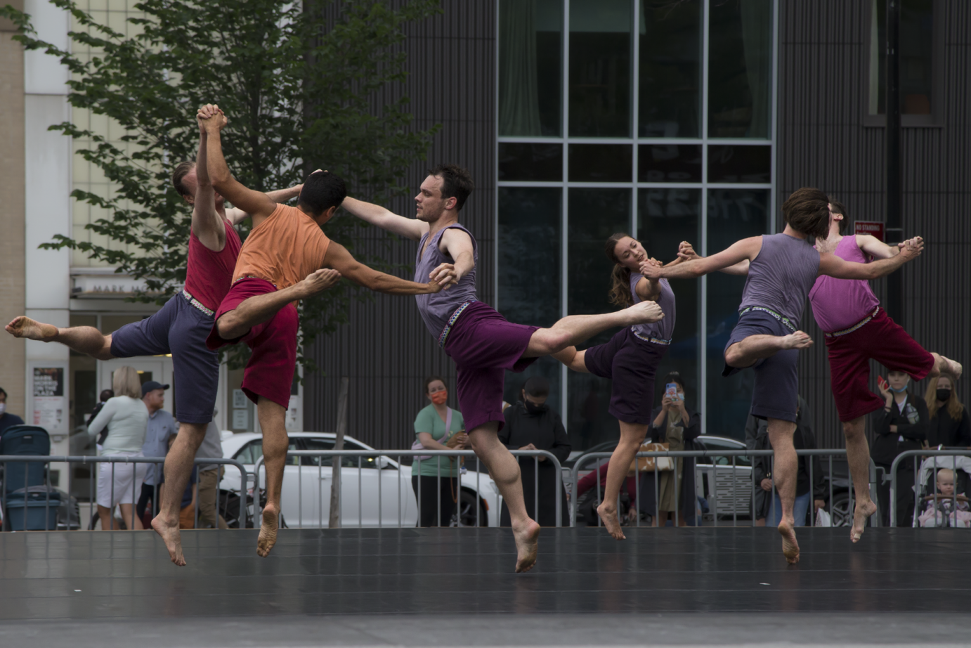 Two trios of dancers holding hands and exuberantly jumping