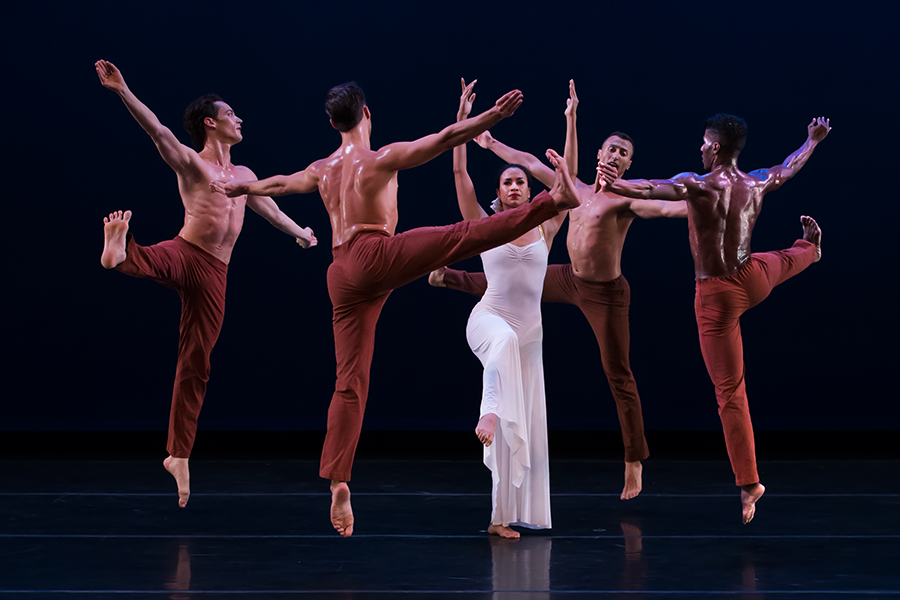 sweat glistening male bodies, surround a female all in white symbolizing pure love