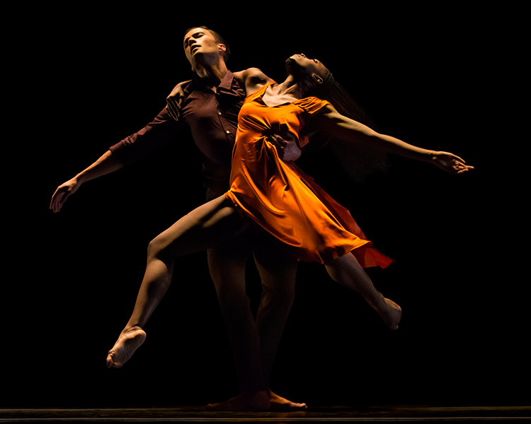 The man in maroon swings his upper body to the leftand his partner swings her body to the right as he carries her. She appears to be gliding.