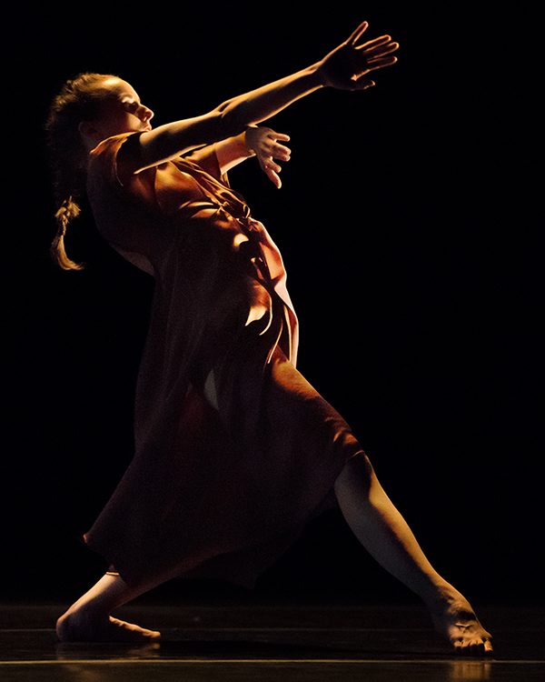 a solo female figure reaches out in the darkness.