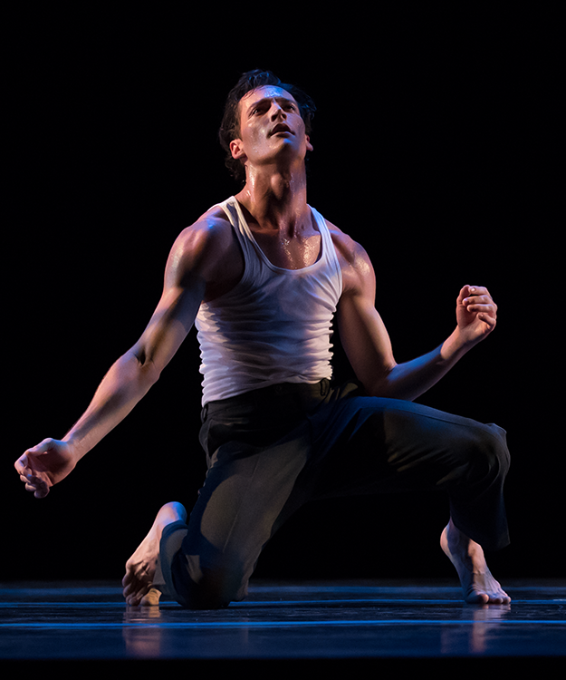 as he bends in to almost a kneel, the dancer gazes upward, his torso contracts downward and to the back
