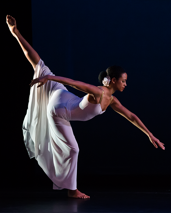 the woman in white in a beautiful deep arabesque with her supporting leg in plie. She looks serene. 