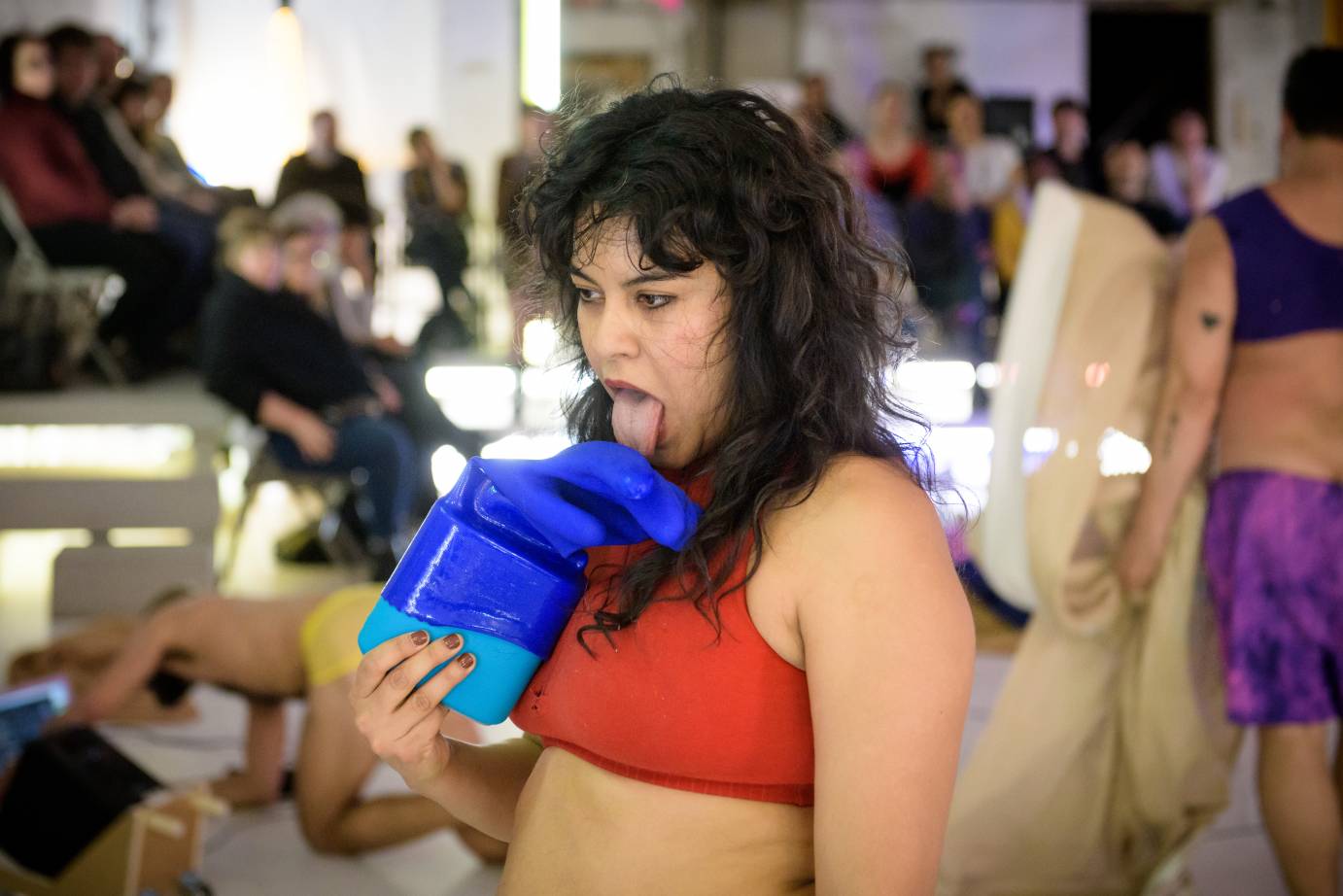 A woman licks a blue object