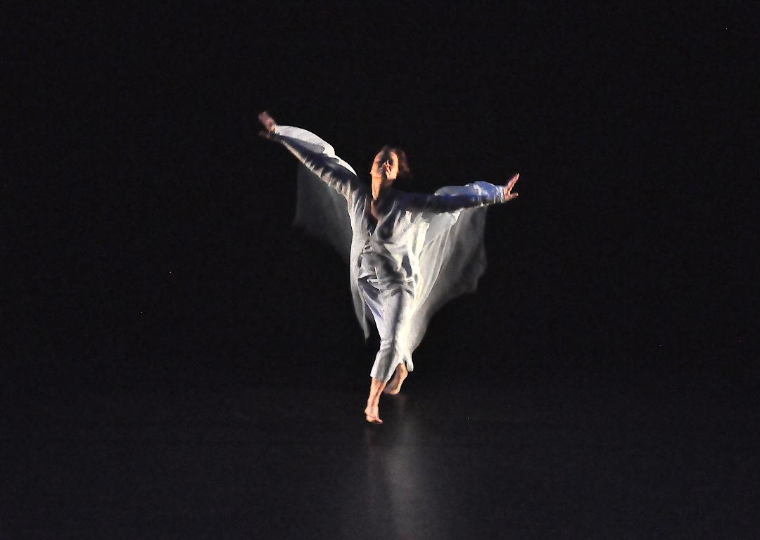 A woman in white runs toward the audience