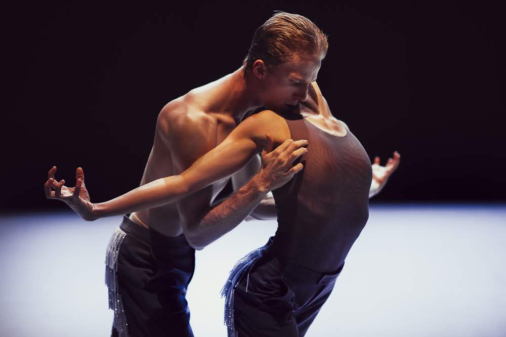 A woman bows her body as a man holds her under the arms