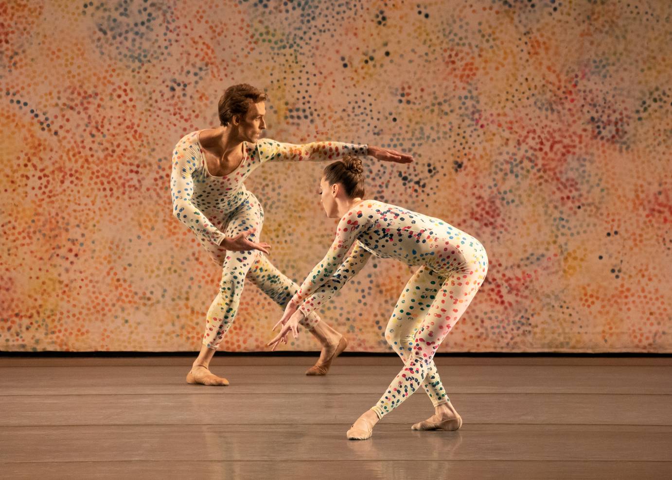 A man and a woman make sculptural shapes with their arms and legs