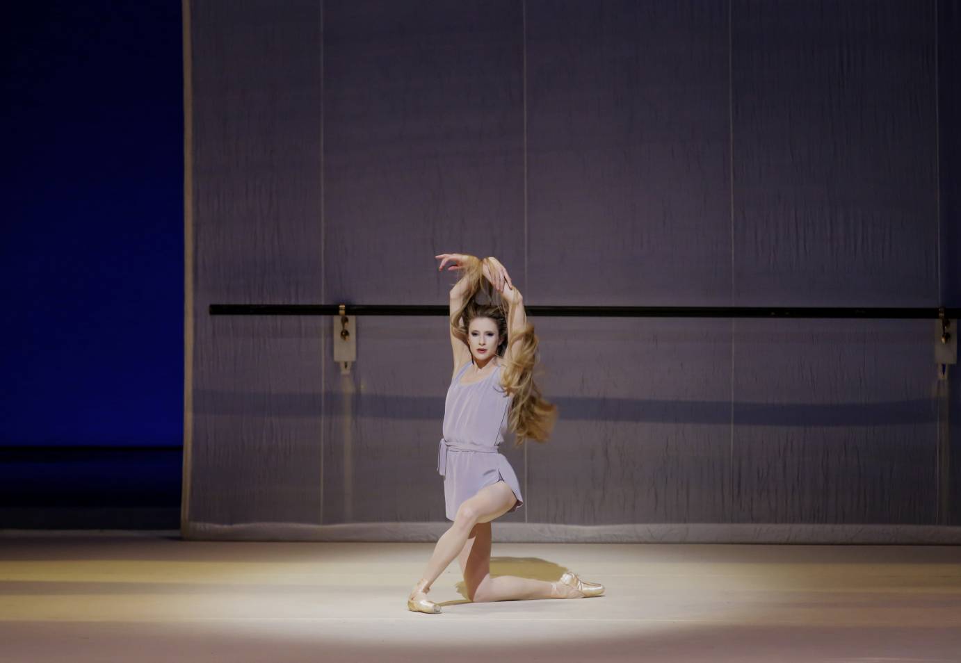 Sterling Hyltin kneels and her arms are above her head.