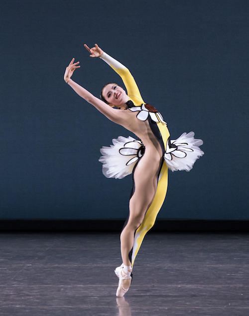 A ballet dancer in a unitard that is nude on one side and yellow and bedazzled on the other.