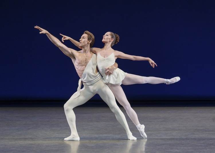 apollo in white and his muse Terpsichore. he points towards the sky as she leans on him in a low arabesque