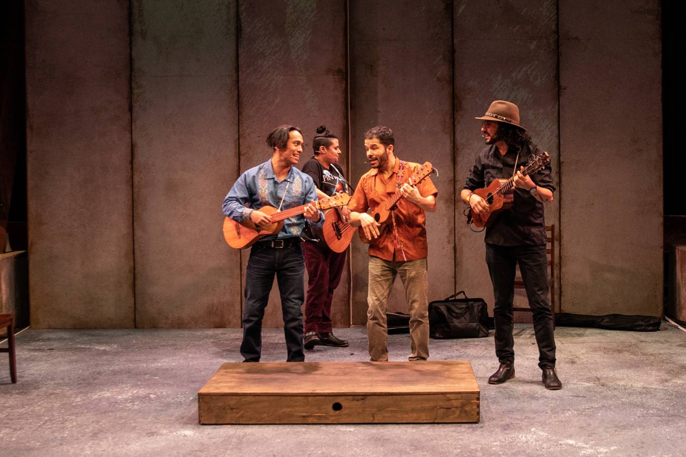 A cluster of men play stringed instruments