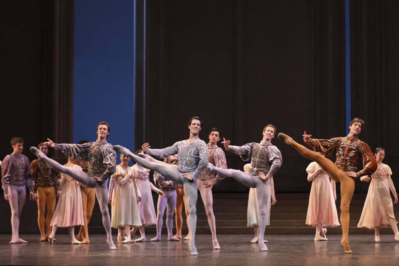 Four men extend their legs in front of a smiling women