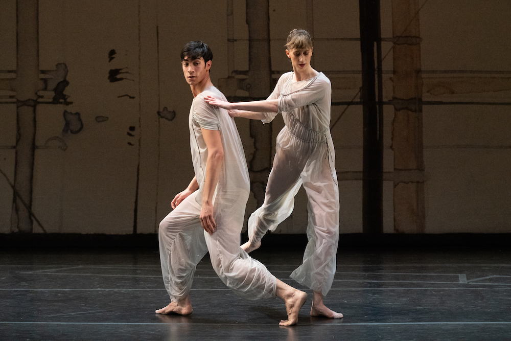 an intimate moment with two dancers one on bent knee and the other leaning on her partner for support