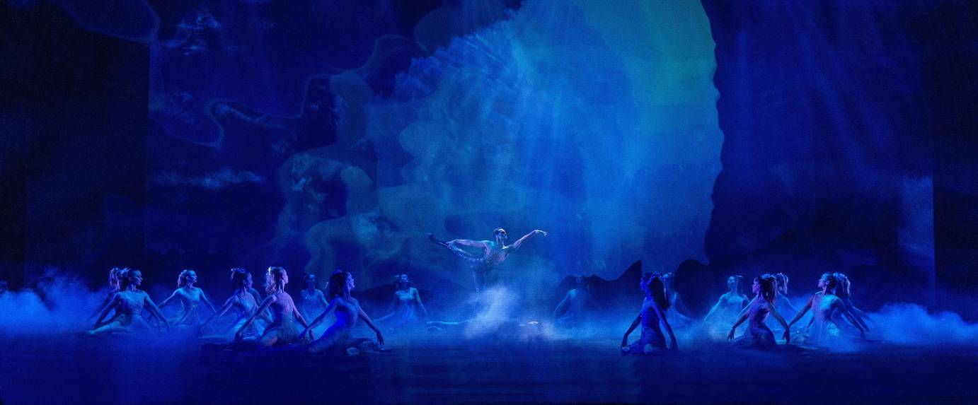 The blue grotto with one man in arabesque in center surrounded by water nymphs