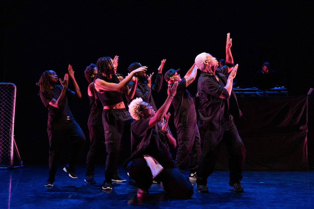 the company in profile arms swinging upwards one knee lifted in unison