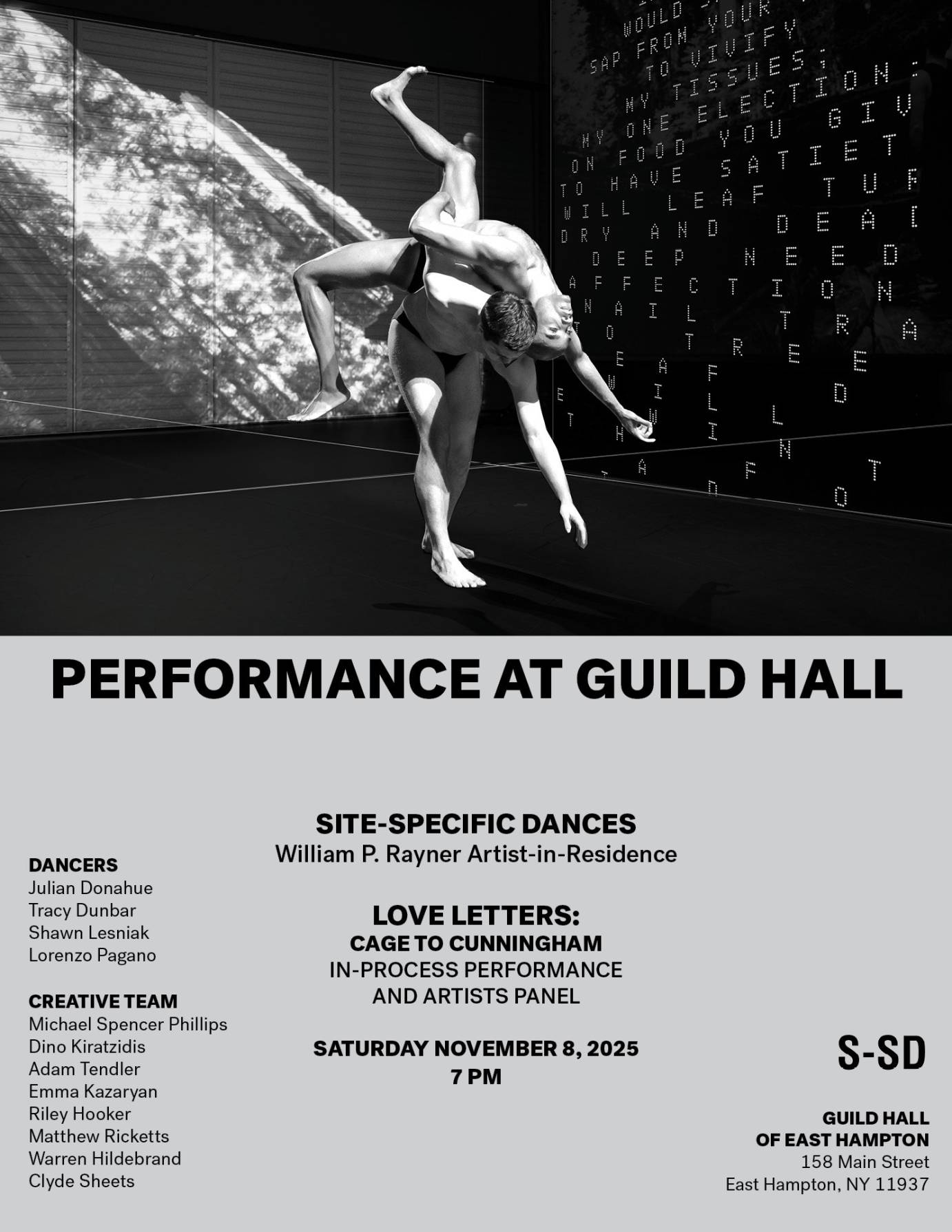 two men wearing dance belts. one carries the other on his back, the one being carried lies across the carrier with one leg bent toward the sky and the other toward the floor. in the back and on the side wall there are projections of nature and words