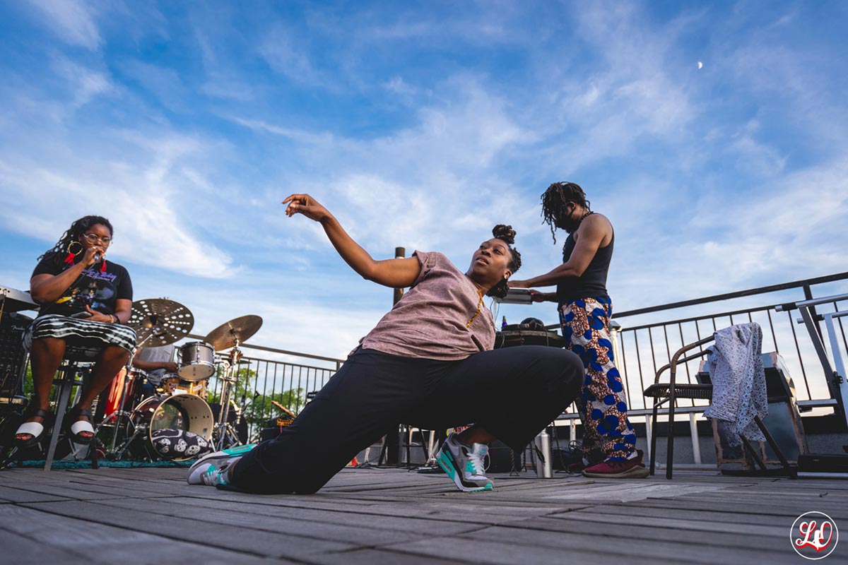 aBlack womanon thegrounddancing the sky behind her bright blue