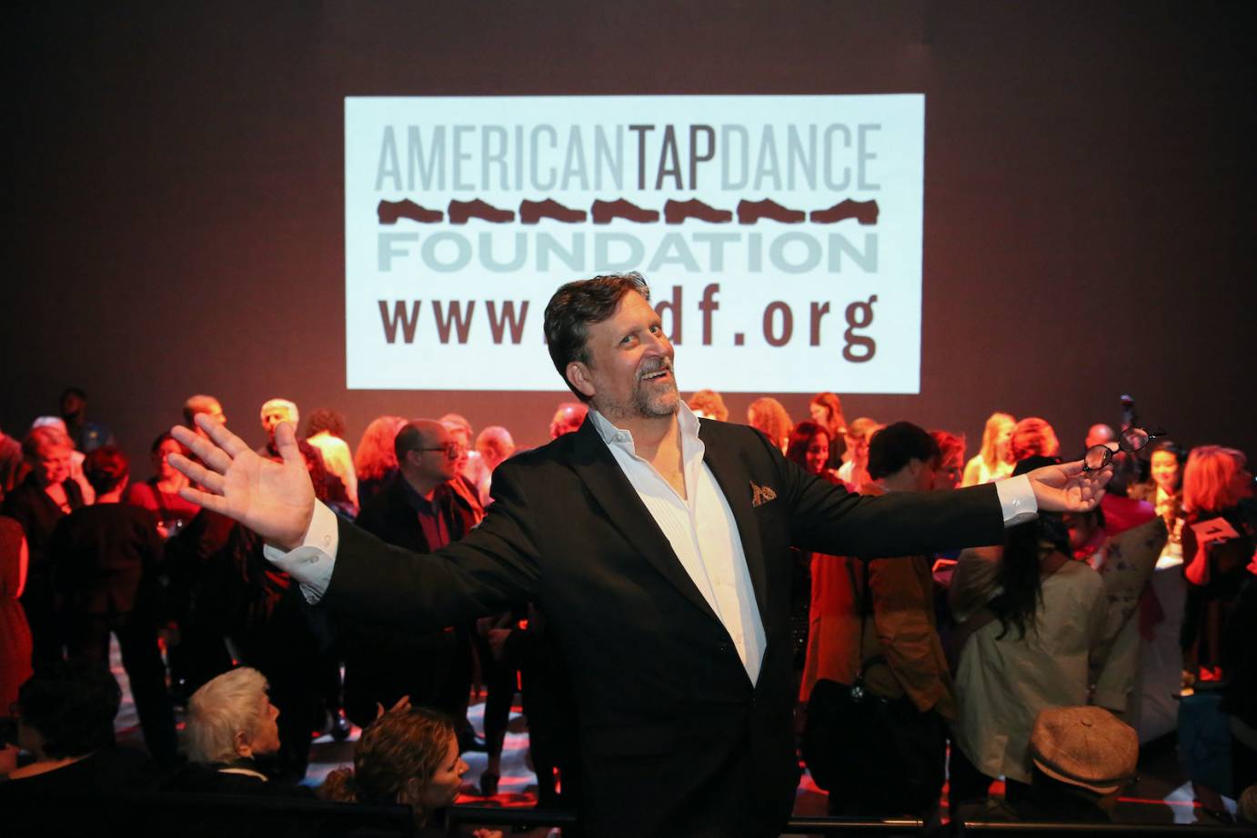 Tony Waag mugs for the camera as a true showman right in front of a sign for the American Tap Foundation