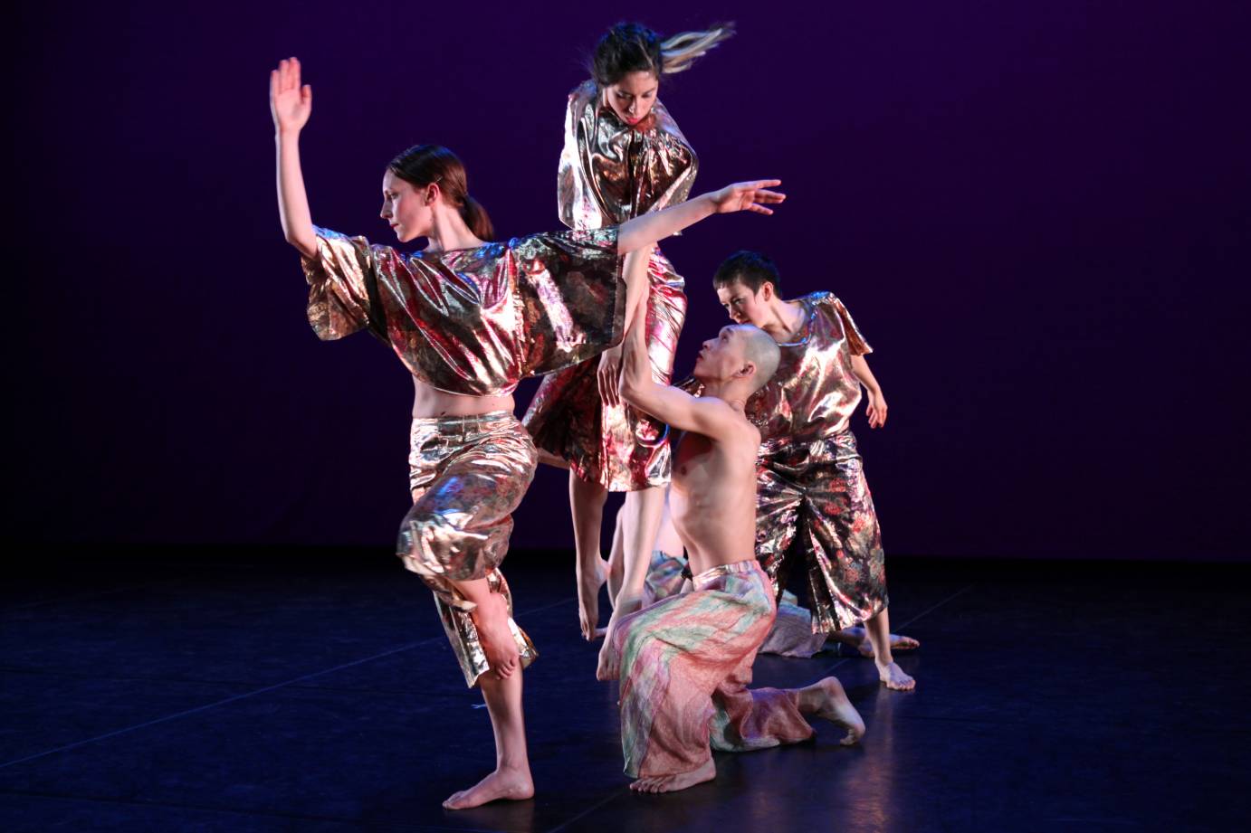 dancers clad in bright glittering colors create a twisted movement tableau