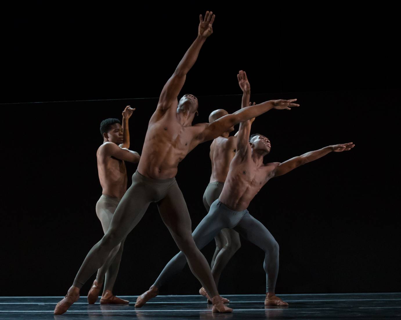 for barechested Black men extend their arms out in front of them