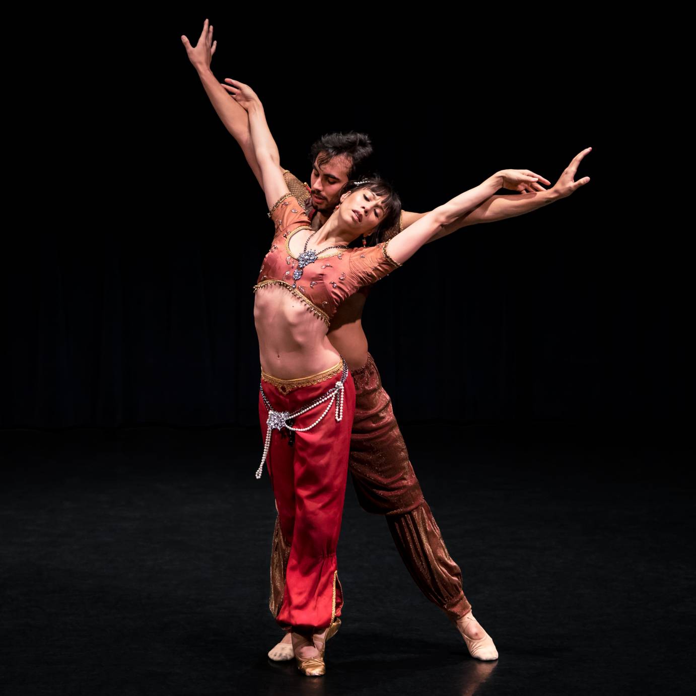 A woman leans against a man provocatively