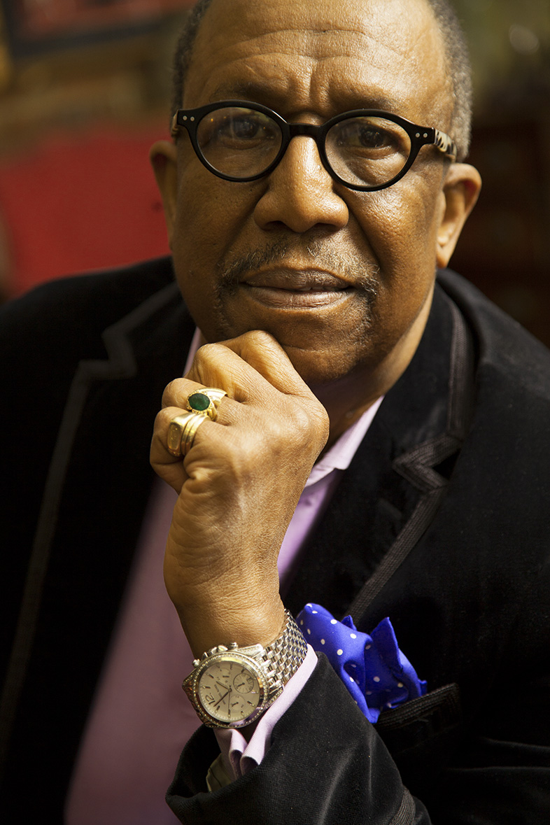 A headshot of George Faison in which he gently holds his chin and looks straight at the camera