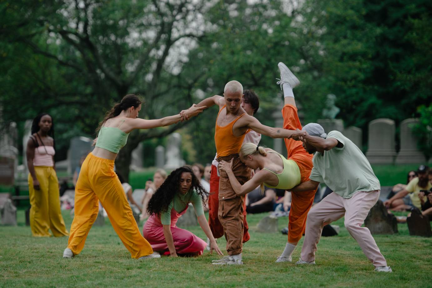 A group of dancers connect limbs and hands to form living sculpture