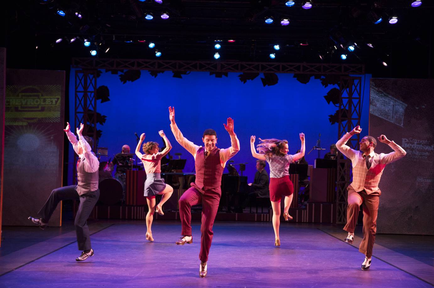 Three men and three women lift their arms above their heads while the heel of one foot rests near the knee of a different leg.