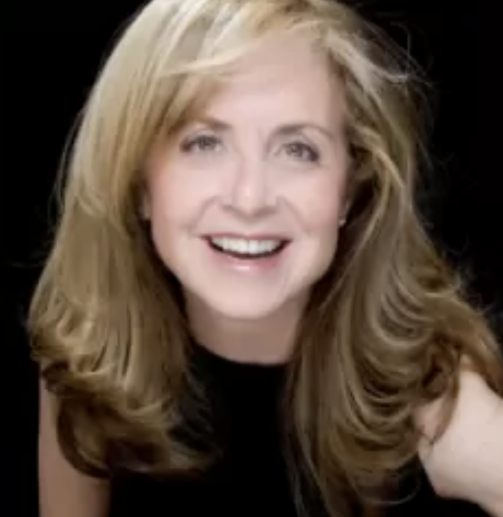 The headshot of Nikki Feirt Atkins features a woman with blonde hair and a big smile.