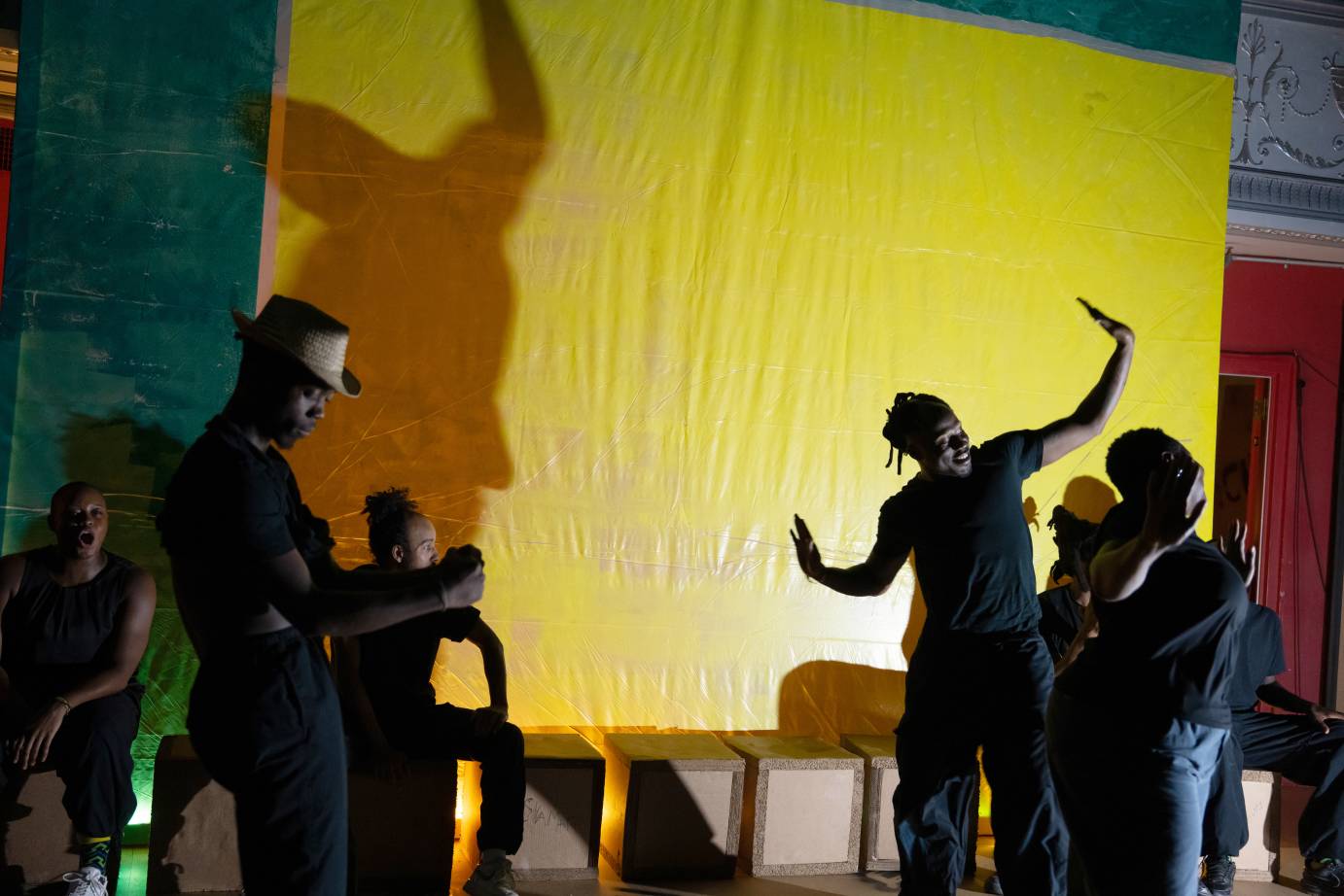 bodies and their shadows  against a yellow screen 
